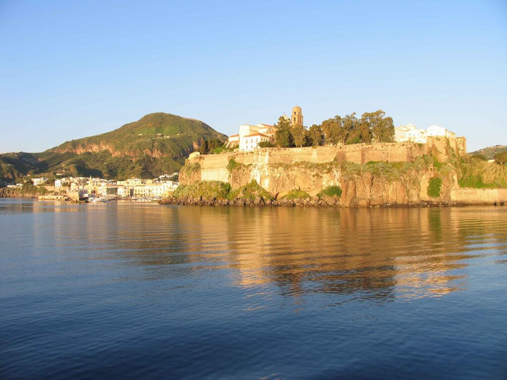 Architettura eoliana: case, terrazze e colori — Vista del Castello di Lipari e del Monte Guardia alle sue spalle