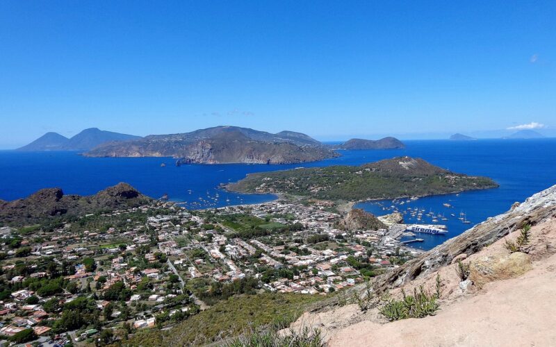 Il mare di Lipari con vento: come scegliere la costa — Ascensione al Gran Cratere (386), Panorama. Sullo sfondo al centro l'isola di Lipari, Vulcanello, la spiaggia le Sabbie Nere a nord e Sabbie
