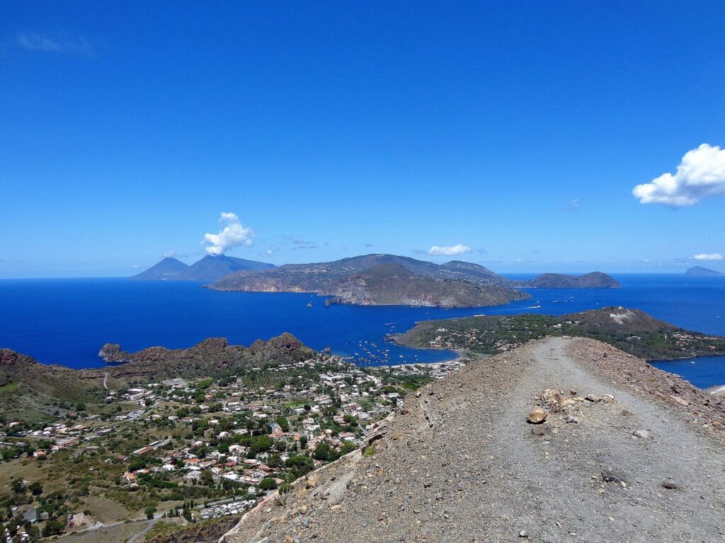 Il giro panoramico di Lipari in scooter — Ascensione al Gran Cratere (386), Panorama. Sullo sfondo al centro l'isola di Lipari, a sinistra il profilo di Salina, a destra Vulcanello c