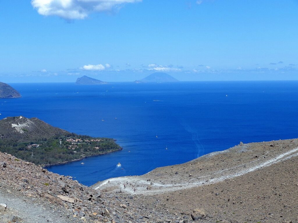 Un itinerario fotografico tra alba e tramonto — Ascensione al Gran Cratere (386), Panorama. Sullo sfondo al centro l'isola di Lipari col monte Rosa, al centro Vulcanello, l'isola di Panare