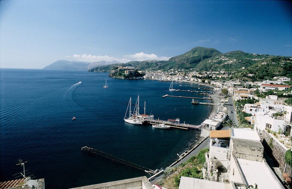 Itinerario a piedi nel centro storico di Lipari — Von der Straße SP 150 nach Canneto Richtung Süden, in Bildmitte liegt der Akropolisfelsen mit dem Kastell und links im Hintergrund die Nachb