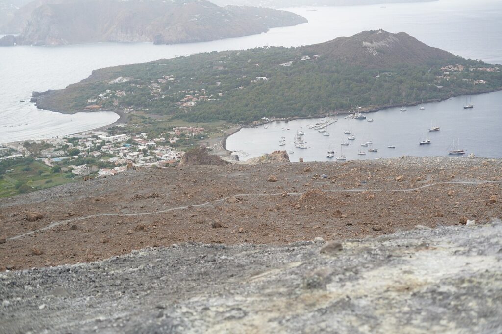 Belvedere Quattrocchi: panorama su Vulcano — View from the crest of the Gran Cratere down toward the isthmus of Vulcano and Vulcanello, with the harbour and the island of Lipari beyond,